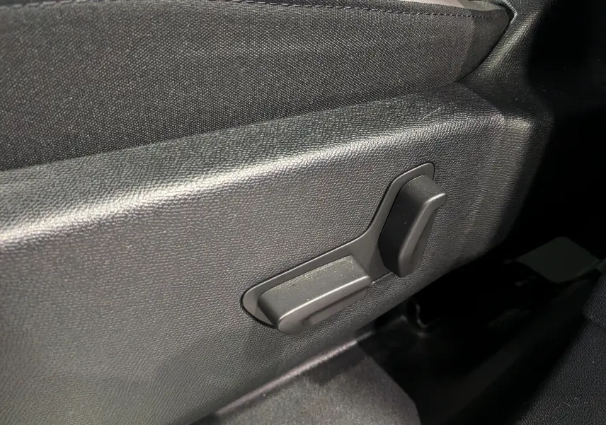 Gros plan sur les commandes électriques du siège conducteur du Citroën C5 Aircross hybride blanc, intérieur noir.