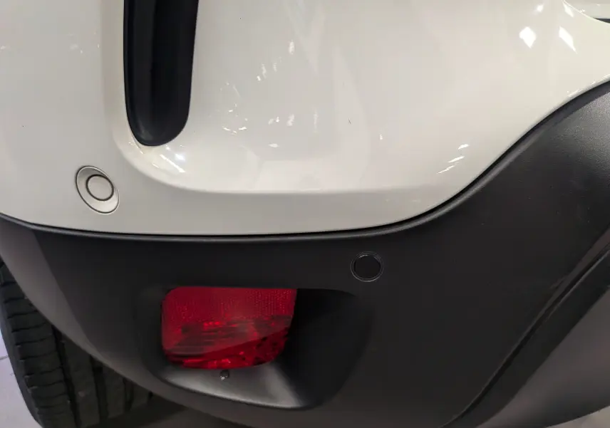 Gros plan sur le feu arrière droit rouge et le pare-chocs noir du Citroën C5 Aircross blanc glacier hybride rechargeable.