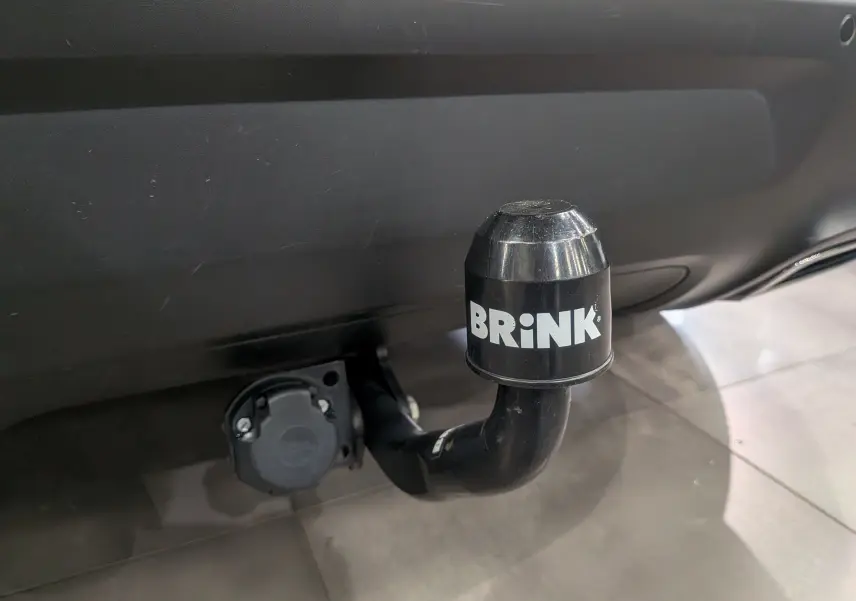 Gros plan sur l'attelage de remorque noir marqué BRINK sous le pare-chocs arrière du Citroën C5 Aircross blanc Glacier.