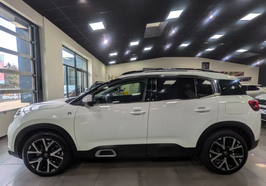 Profil côté gauche du Citroën C5 Aircross blanc glacier en hybride rechargeable, avec jantes noires et toit panoramique.