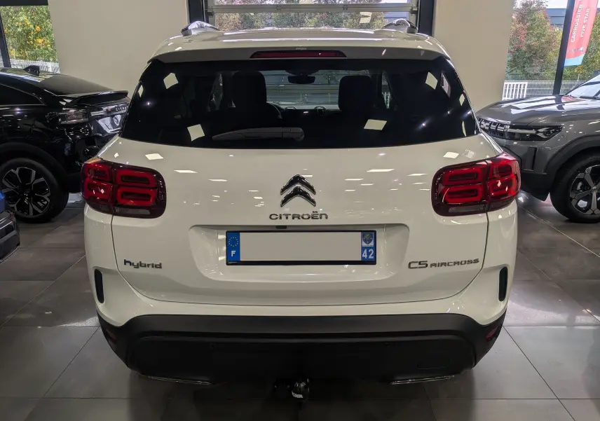 Vue arrière du Citroën C5 Aircross hybride rechargeable blanc glacier, avec feux arrière distinctifs et attelage visible.