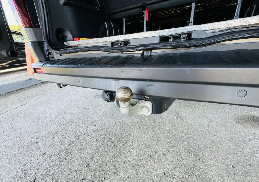 Gros plan sur l'attelage arrière gris du Nissan NV300 Combi avec porte ouverte et plancher visible.