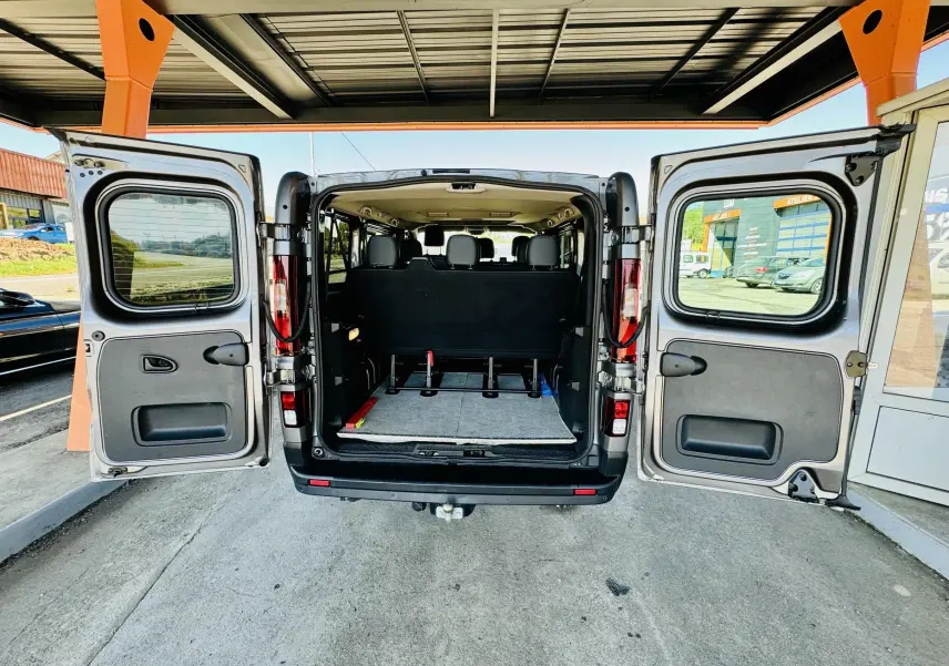 Vue arrière du Nissan NV300 Combi gris 2018 avec portes battantes ouvertes montrant l'intérieur et les sièges noirs.