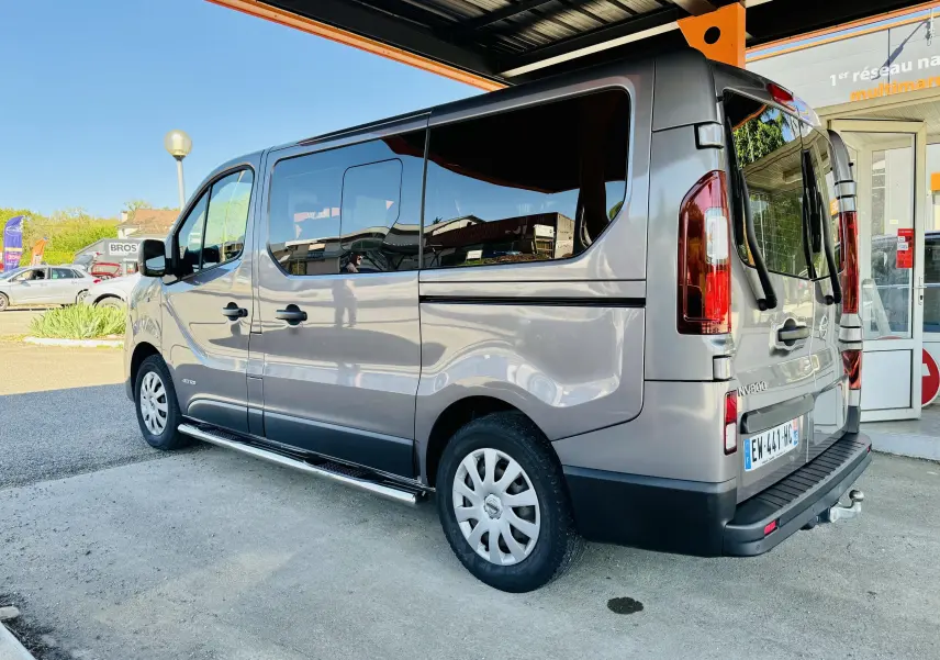 Vue 3/4 arrière droite d’un Nissan NV300 Combi gris avec vitres teintées et marchepied latéral.