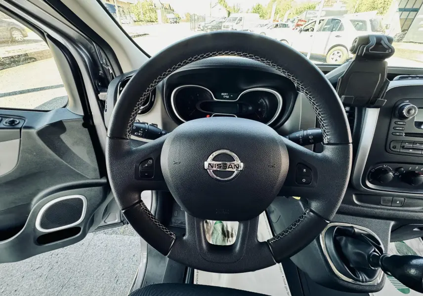 Vue intérieure centrée sur le volant noir du Nissan NV300 Combi 2018 avec tableau de bord et levier de vitesses manuelle.