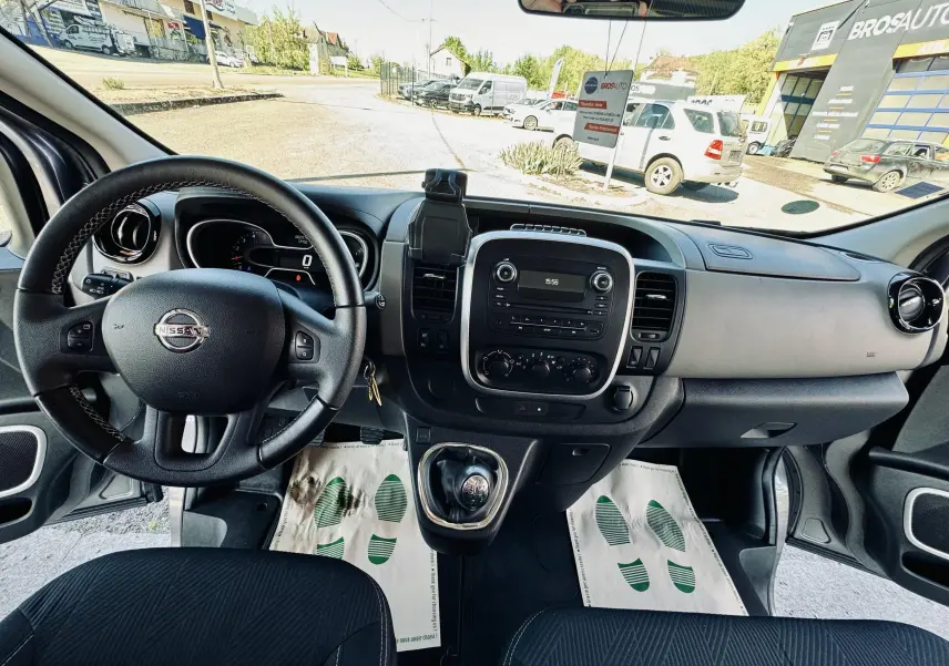 Vue intérieure avant du Nissan NV300 Combi 2018, tableau de bord gris avec volant à gauche et levier de vitesses manuel.