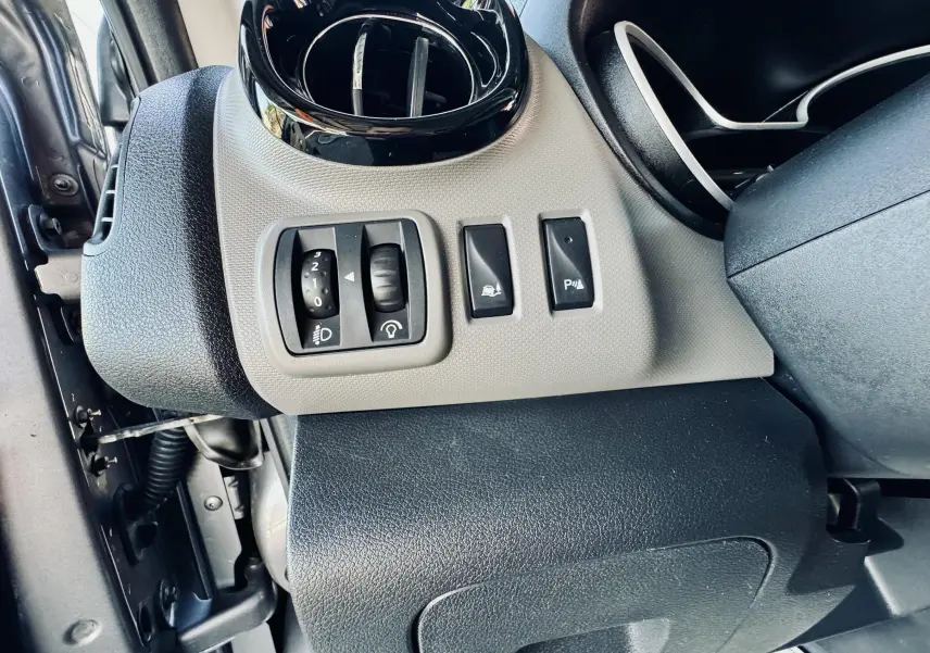 Détail des commandes côté gauche du tableau de bord gris et noir du Nissan NV300 Combi 2018.