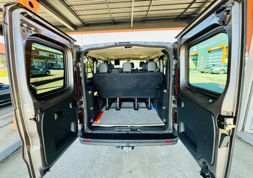 Vue arrière du Nissan NV300 Combi gris avec portes ouvertes montrant l'espace intérieur et les sièges arrière.
