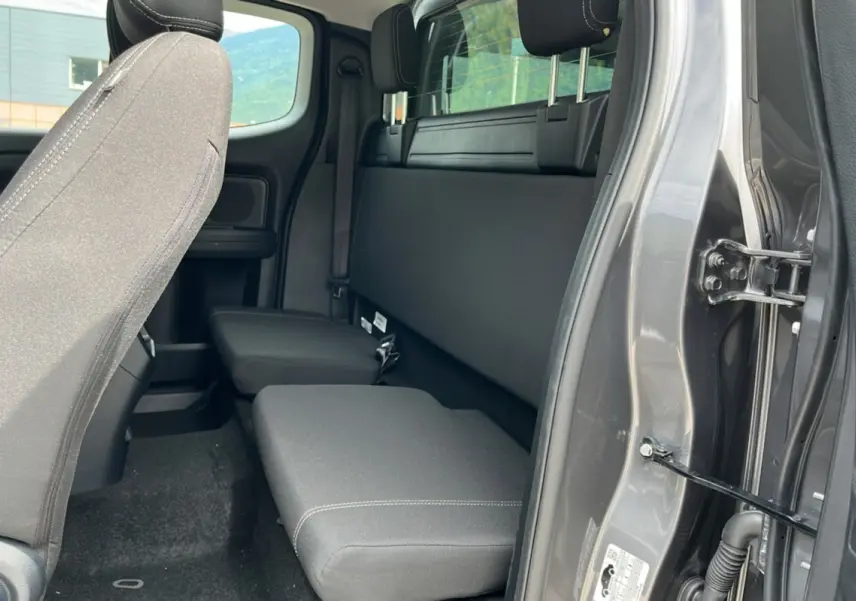 Vue intérieure côté droit du Ford Ranger gris carbone 2025, montrant la banquette arrière et l'ouverture de porte.
