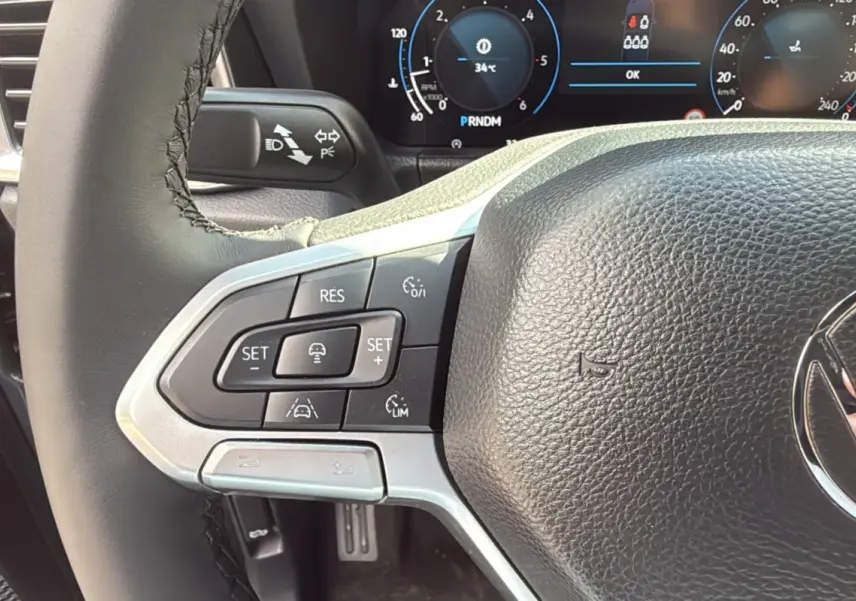 Gros plan sur le volant cuir multifonctions du Volkswagen Amarok 2026, avec commandes de régulateur et affichage digital.