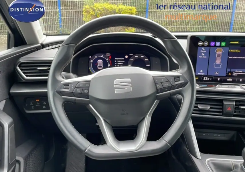 Vue intérieure centrée sur le volant cuir noir et le tableau de bord numérique du SEAT LEON ST 2025.
