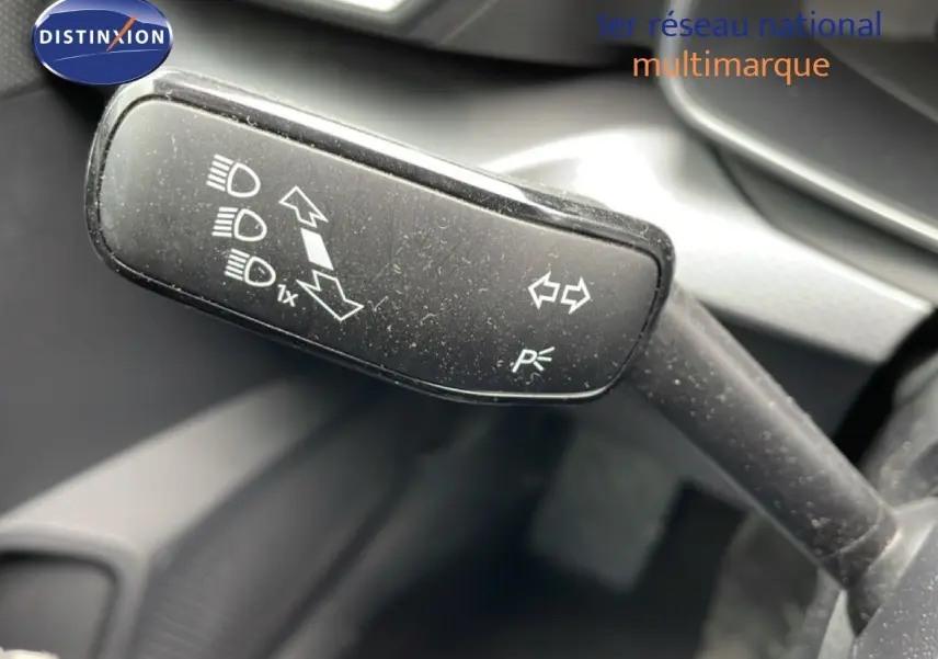 Gros plan sur la manette de clignotants noire à l'intérieur d'une SEAT LEON ST gris magnétique, avec pictogrammes blancs visibles.
