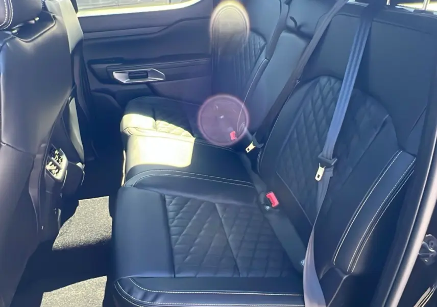 Vue intérieure arrière côté droit du Ford Ranger 2026 noir agate, sièges cuir noir matelassé avec surpiqûres blanches.