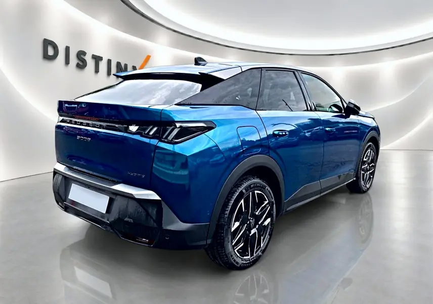 Vue 3/4 arrière droite d'un Peugeot 3008 bleu obsession avec jantes alliage et becquet arrière dans un showroom.