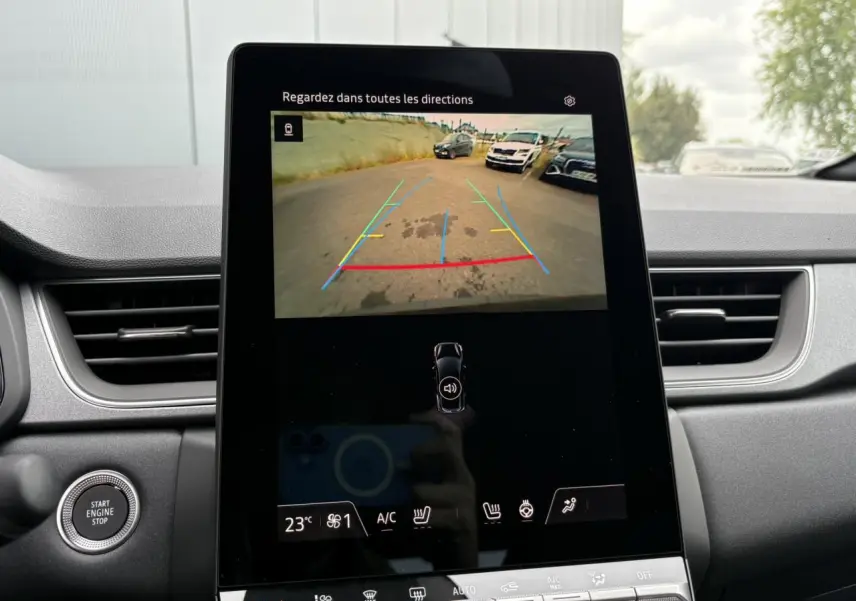 Écran central tactile du Renault Captur 2025 affichant la caméra de recul avec guidage coloré, intérieur gris.