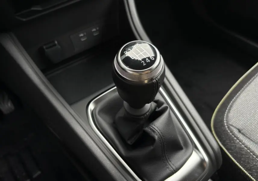 Le levier de vitesses manuel noir du Renault Captur 2025 avec coutures apparentes et console sombre.