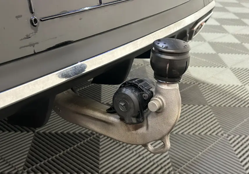 Gros plan sur l'attelage arrière droit noir métallisé d'une Mercedes Classe CLA Shooting Brake II 200D AMG.