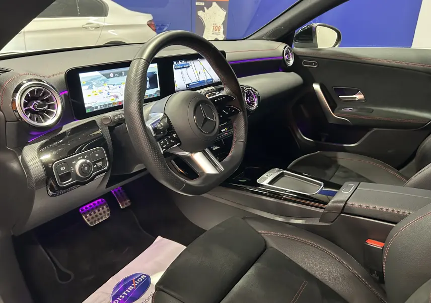 Intérieur noir avec surpiqûres rouges de la Mercedes CLA Shooting Brake II 200D AMG, vue côté conducteur, tableau de bord digital.