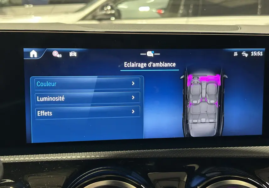 Écran tactile intérieur montrant les réglages d'éclairage d'ambiance avec une vue schématique des sièges en violet.
