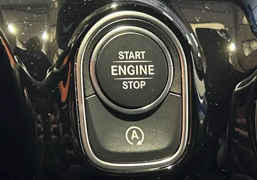 Gros plan sur le bouton noir brillant Start Engine Stop du tableau de bord d'une Mercedes CLA Shooting Brake 2024.