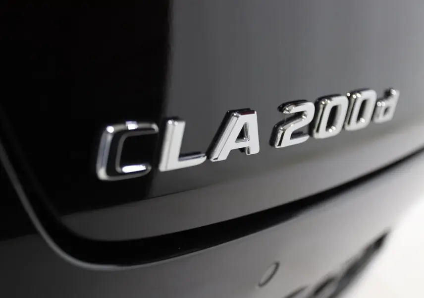 Gros plan sur l'inscription CLA 200d argentée sur la carrosserie noire métallisée arrière du Mercedes CLA Shooting Brake.