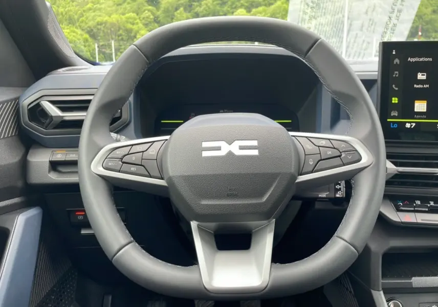 Vue rapprochée du volant cuir noir du Dacia Bigster 2025, avec commandes intégrées et écran tactile central visible.