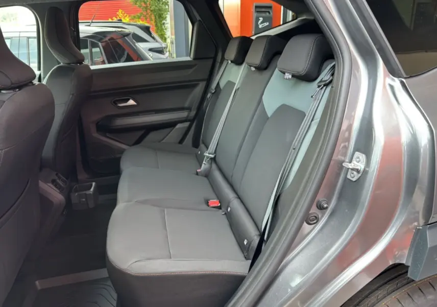 Vue côté gauche de la banquette arrière grise du Dacia Bigster 2026, avec ceinture de sécurité et porte ouverte.