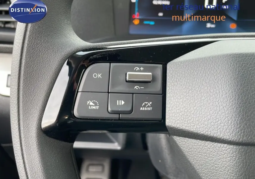 Gros plan sur les commandes au volant à gauche du Citroën Jumpy Cabine Approfondie gris titane, affichage numérique en arrière-plan.