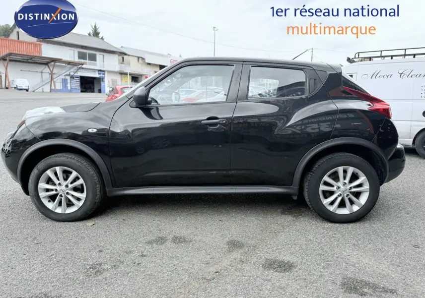 Profil côté gauche d'un Nissan Juke noir de 2012, compact et urbain, garé sur un parking extérieur.