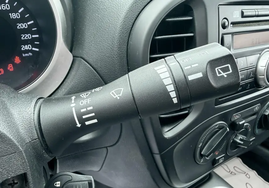 Gros plan sur la commande d’essuie-glace à gauche du volant du Nissan Juke noir, avec tableau de bord et console centrale visibles.