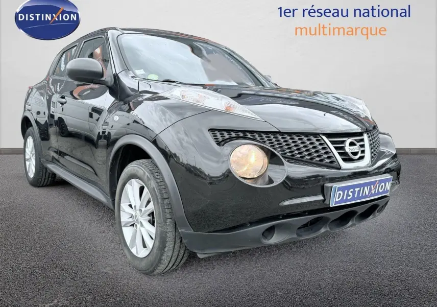Nissan Juke noir en 3/4 avant droit avec phare avant allumé sur fond neutre.
