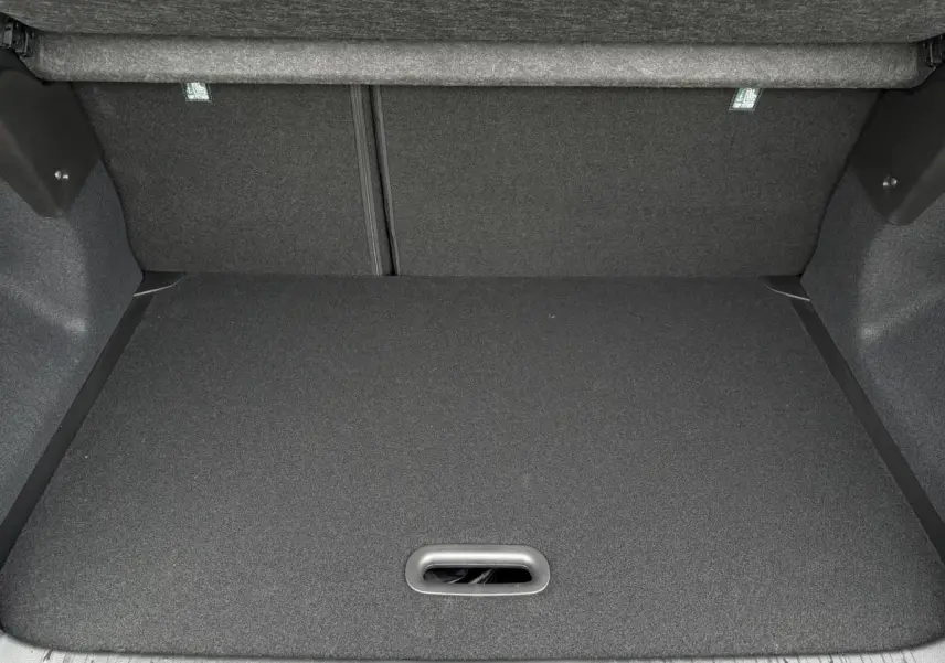 Coffre spacieux et vide du Renault Captur Noir Étoile 2025 vu de l'arrière, avec plancher plat et revêtement sombre.