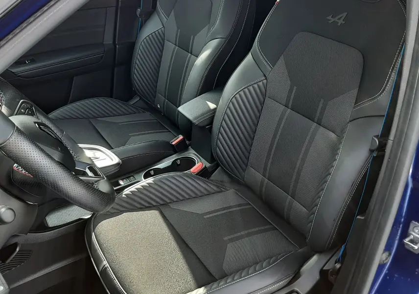 Vue intérieure côté conducteur du Renault Captur 2024, sièges noirs avec logo Alpine brodé sur les appuie-têtes.