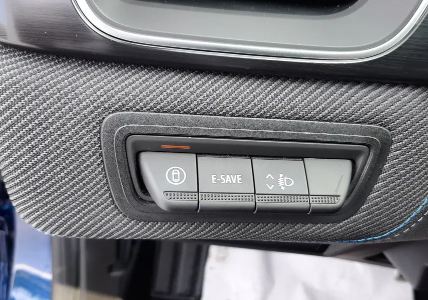 Gros plan sur les boutons de commande sous la ventilation, intérieur noir avec surpiqûres bleues du Renault Captur bleu iron toit noir.