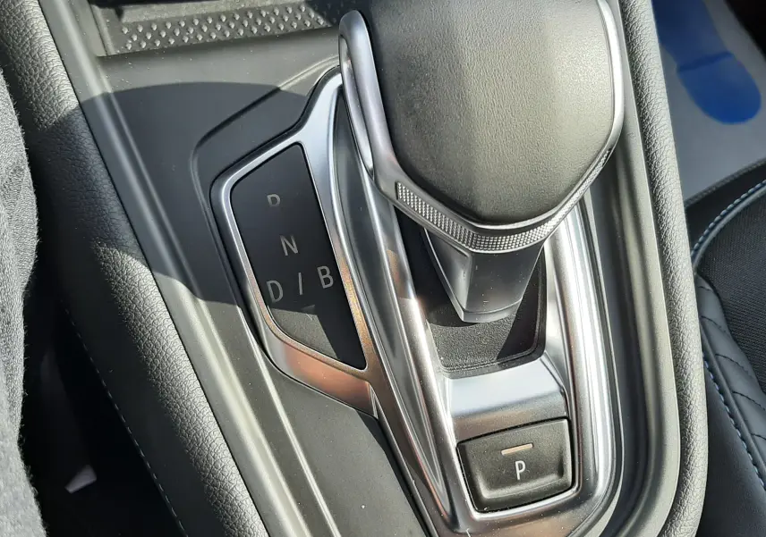 Le levier de vitesses automatique du Renault Captur 2024 hybride, vu en gros plan dans l'habitacle noir.