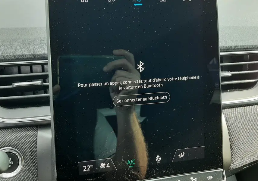Écran tactile central du Renault Captur 2024 affichant la connexion Bluetooth, entouré de commandes climatisation.