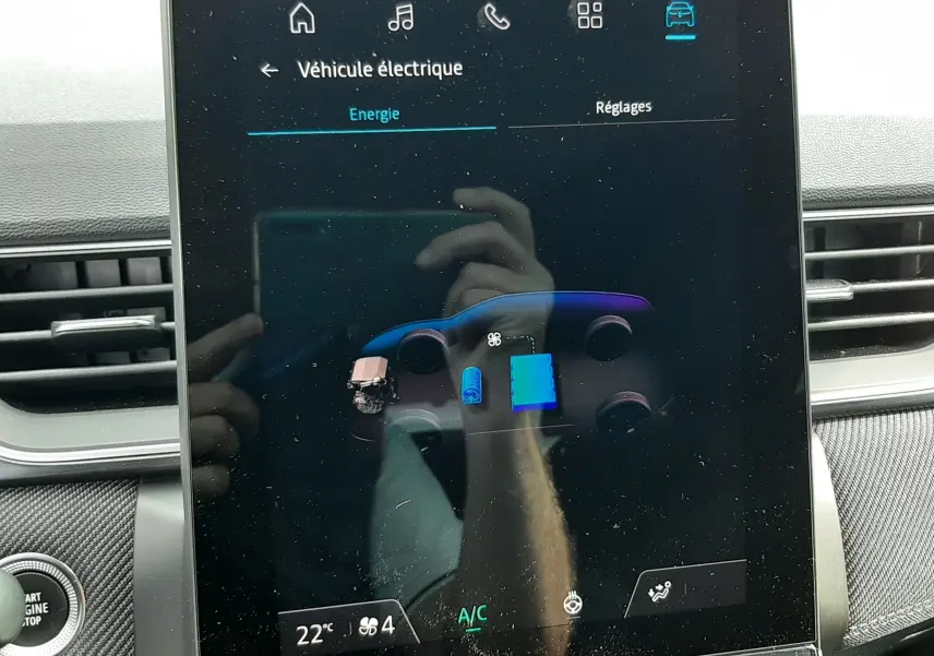 Écran central tactile du Renault Captur 2024 affichant le menu énergie du système hybride, intérieur noir visible.