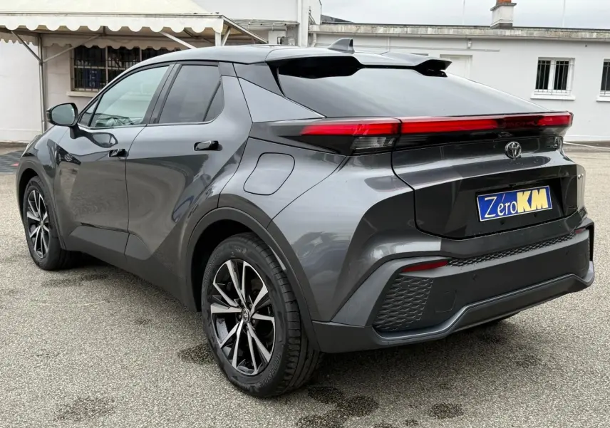 Toyota C-HR 1.8 140CH STYLE gris atlas vu en 3/4 arrière droit, avec feux arrière LED et jantes alliage noires.