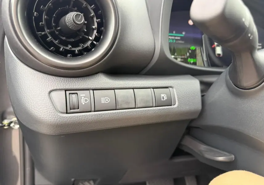 Détail du tableau de bord côté gauche du Toyota C-HR gris atlas 2025, montrant les commandes d'éclairage et de carburant.