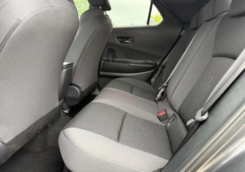 Vue intérieure côté droit des sièges arrière gris foncé du Toyota C-HR 1.8 140CH STYLE MY25, ambiance sobre et moderne.