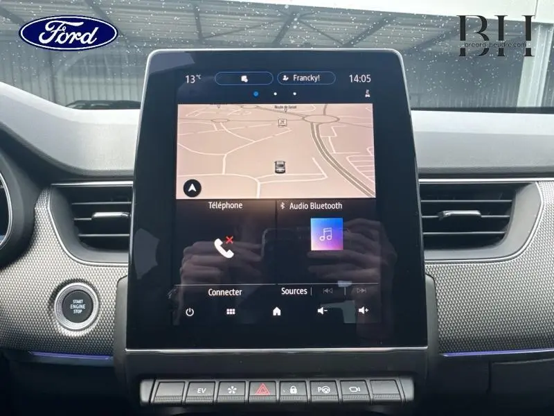 Écran tactile central du tableau de bord avec navigation et commandes multimédia d'une Renault Arkana Bleu Zanzibar vue de face