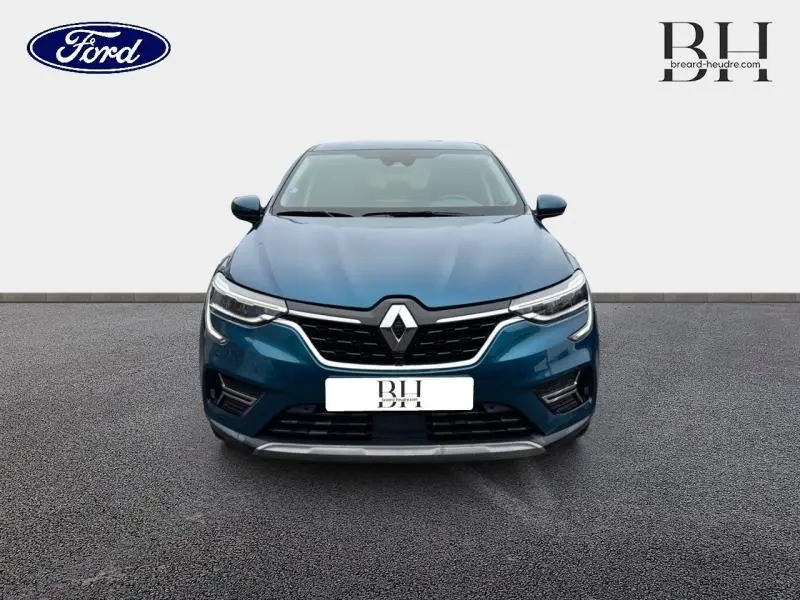 Vue frontale d'un Renault Arkana bleu Zanzibar 2022 avec calandre noire et signature lumineuse LED distinctive.