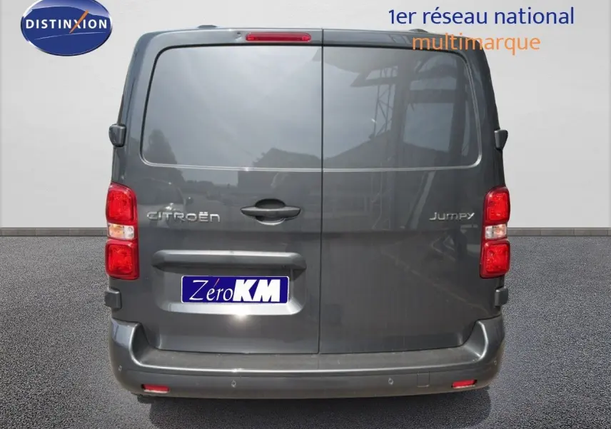 Vue arrière d'un Citroën Jumpy cabine approfondie gris titane métal, portes battantes fermées sur parking.