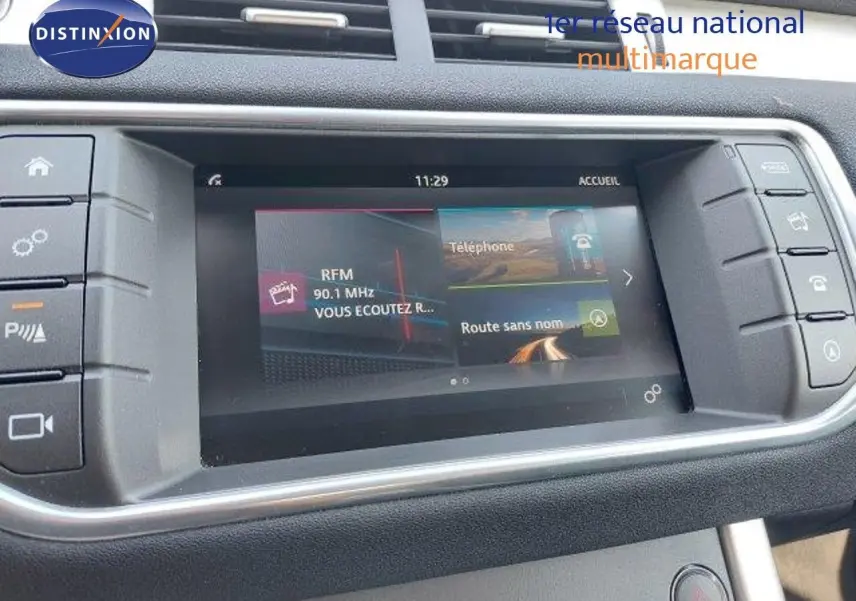 Écran tactile central du Range Rover Evoque blanc 2018 affichant radio et navigation, vue intérieure du tableau de bord.