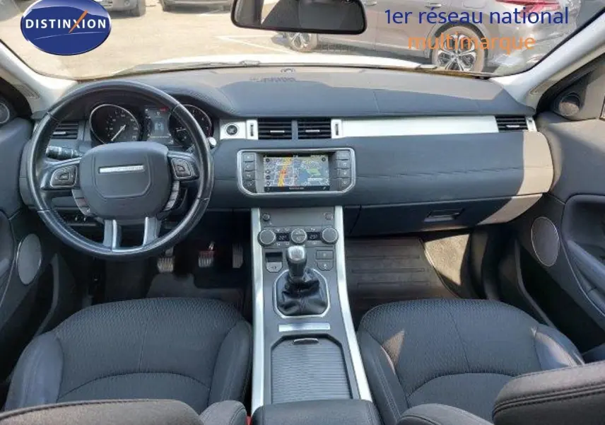 Intérieur du Range Rover Evoque 2018 en vue avant, tableau de bord noir avec écran tactile et boîte manuelle.