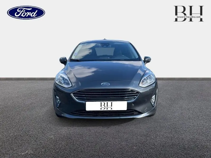 Vue frontale d'une Ford Fiesta 1.1 Titanium 2021 en gris Fashion Magnetic avec calandre chromée et phares LED.