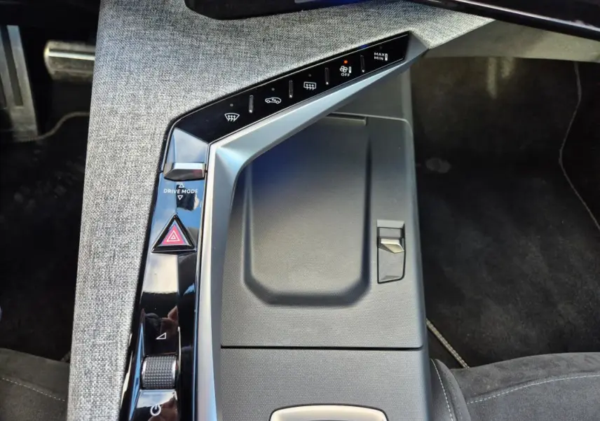 Vue rapprochée de la console centrale grise du Peugeot 3008 Hybrid 136 e-DCS6 GT avec commandes tactiles et bouton Drive Mode.
