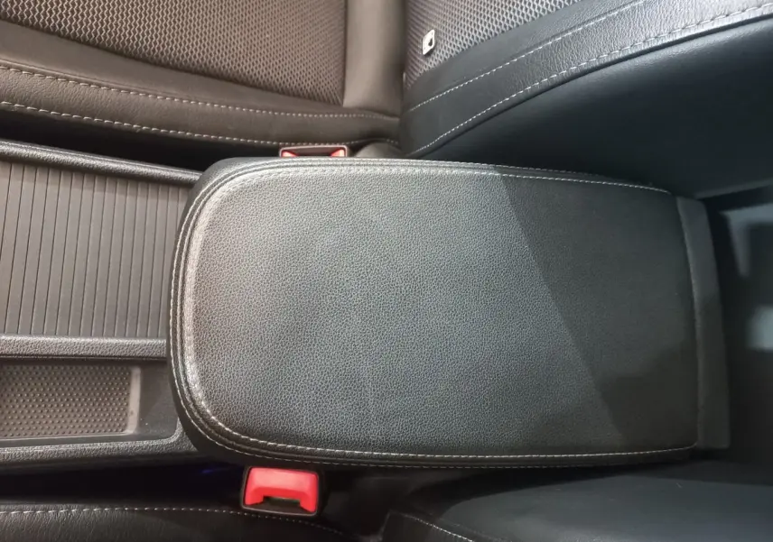 Vue rapprochée de l'accoudoir central en cuir noir avec surpiqûres blanches dans l'habitacle d'une Skoda Octavia 2022.