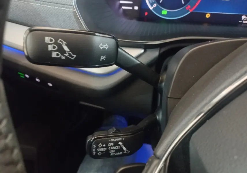 Gros plan sur les commandes au volant de la Skoda Octavia 2022, avec éclairage bleu et tableau de bord numérique.