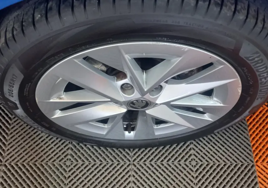 Gros plan sur la jante alliage argentée et pneu Bridgestone d'une Skoda Octavia bleue, vue de dessus.